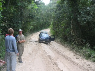 Minivan stuck in the mud on dirt road